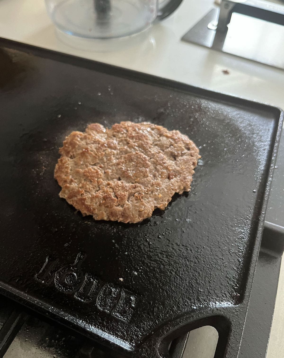 Flipped healthy burger cooking on a griddle.