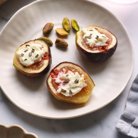 figs with goat cheese on an appetizer plate with pistachios.