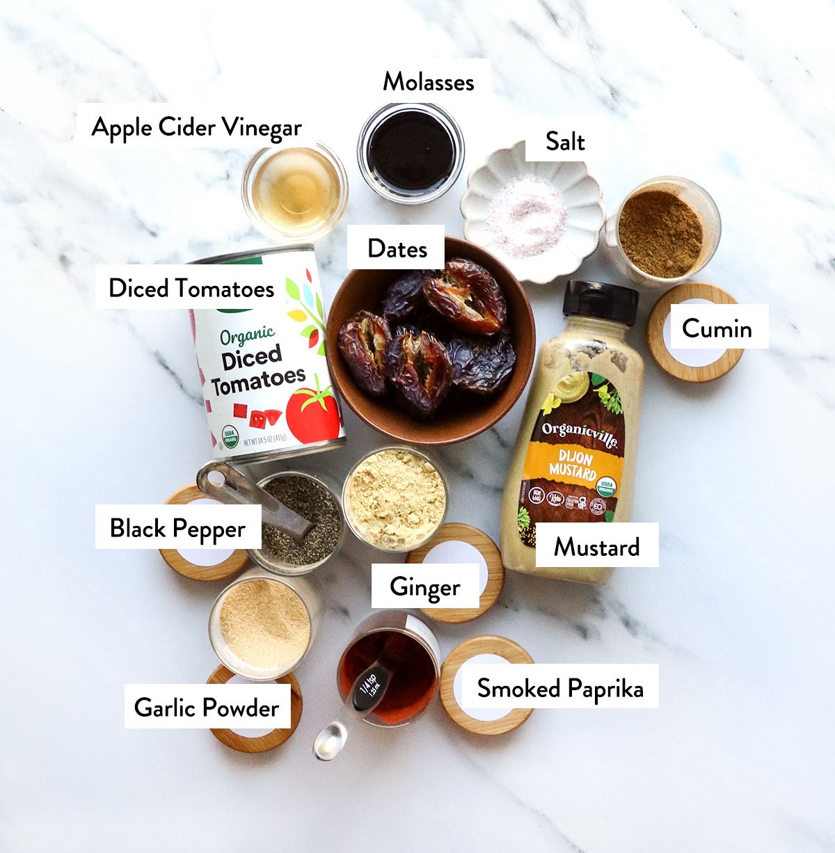 dates, canned tomatoes, mustard, and spices labeled on a white surface.