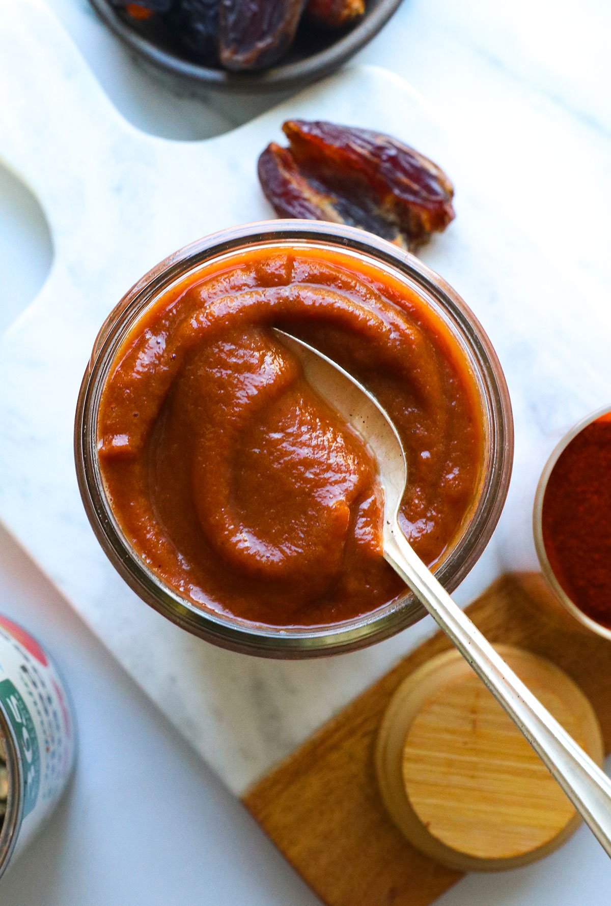 Healthy BBQ sauce in a glass jar with a spoon.