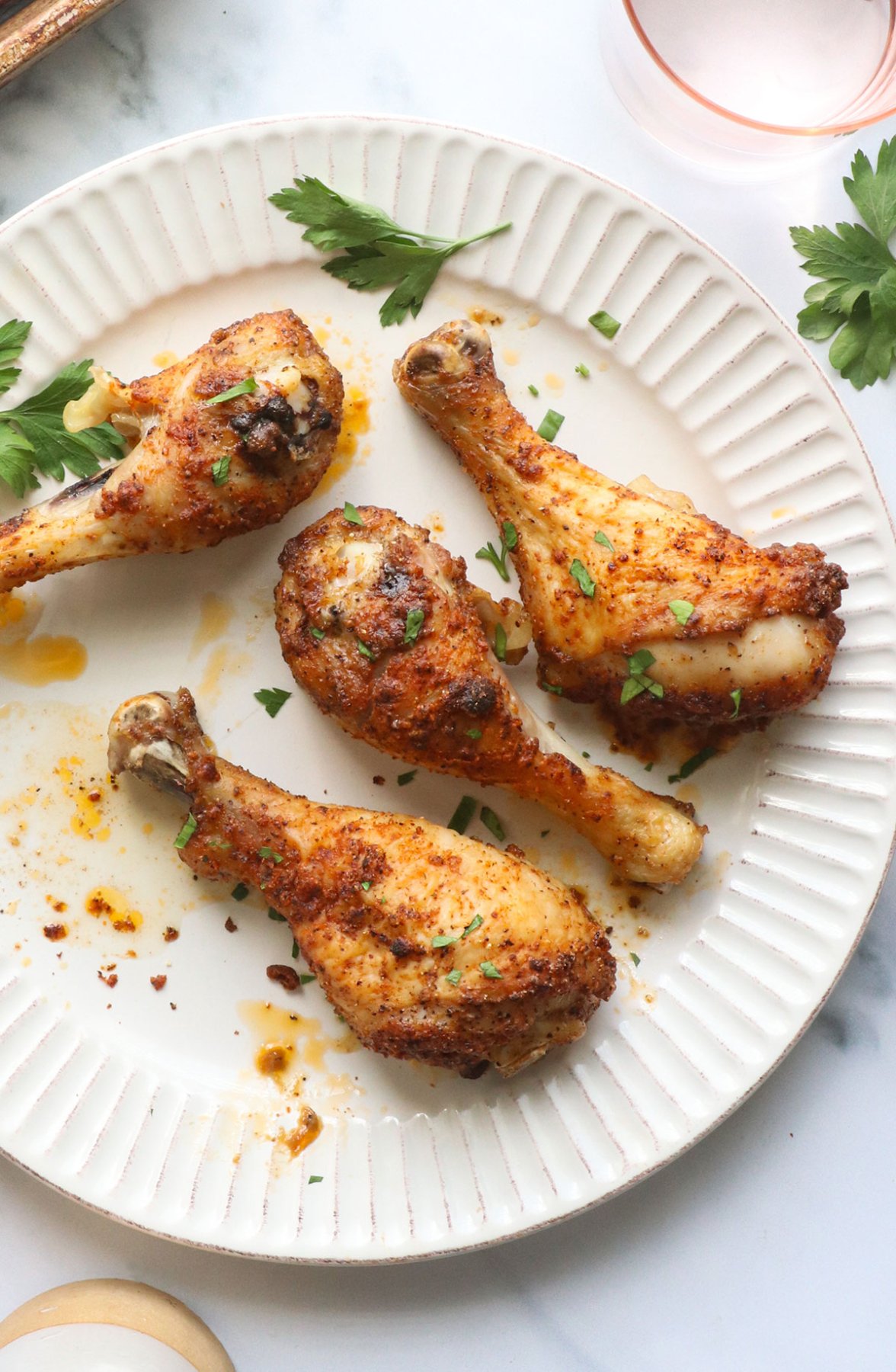 oven baked chicken drumsticks on a white plate for serving. 