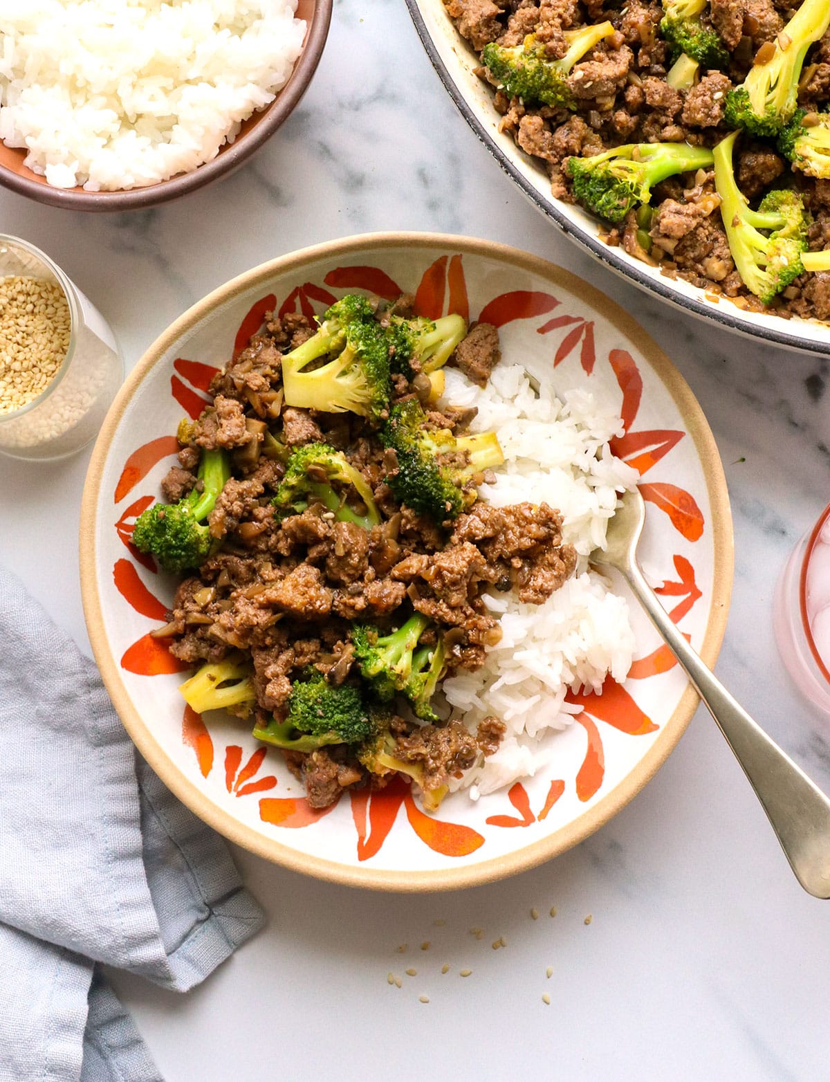 ground beef and broccoli served in a colorful bowl with white rice. 
