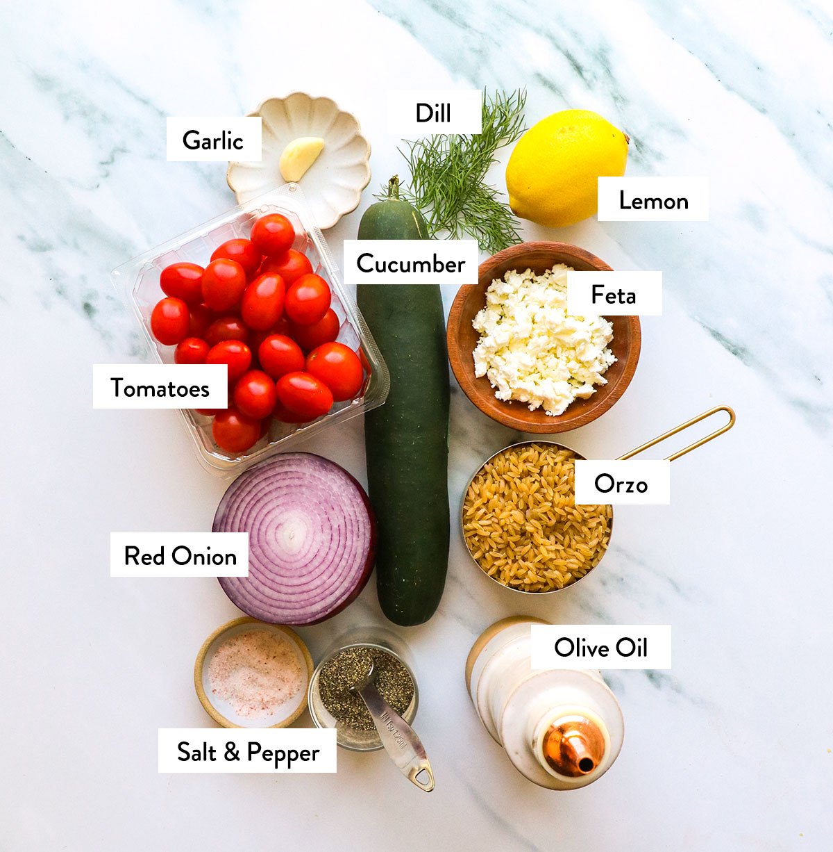 cucumber, tomatoes, red onion, orzo, and herbs labeled on a white surface. 