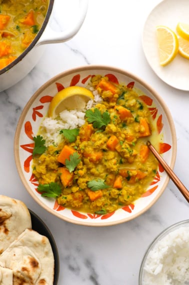 lentil and sweet potato curry served over rice with a lemon and cilantro.