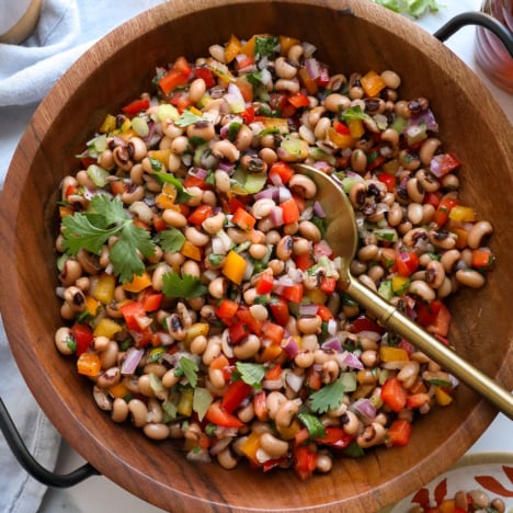 black eyed pea salad served in a wooden salad bowl with a spoon.