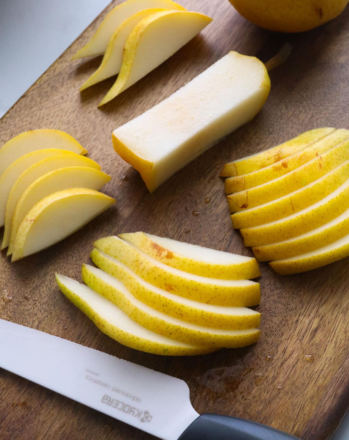fresh bartlett pear sliced into thin pieces for a salad.