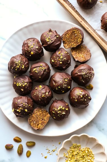 chocolate pistachio balls on a white plate.