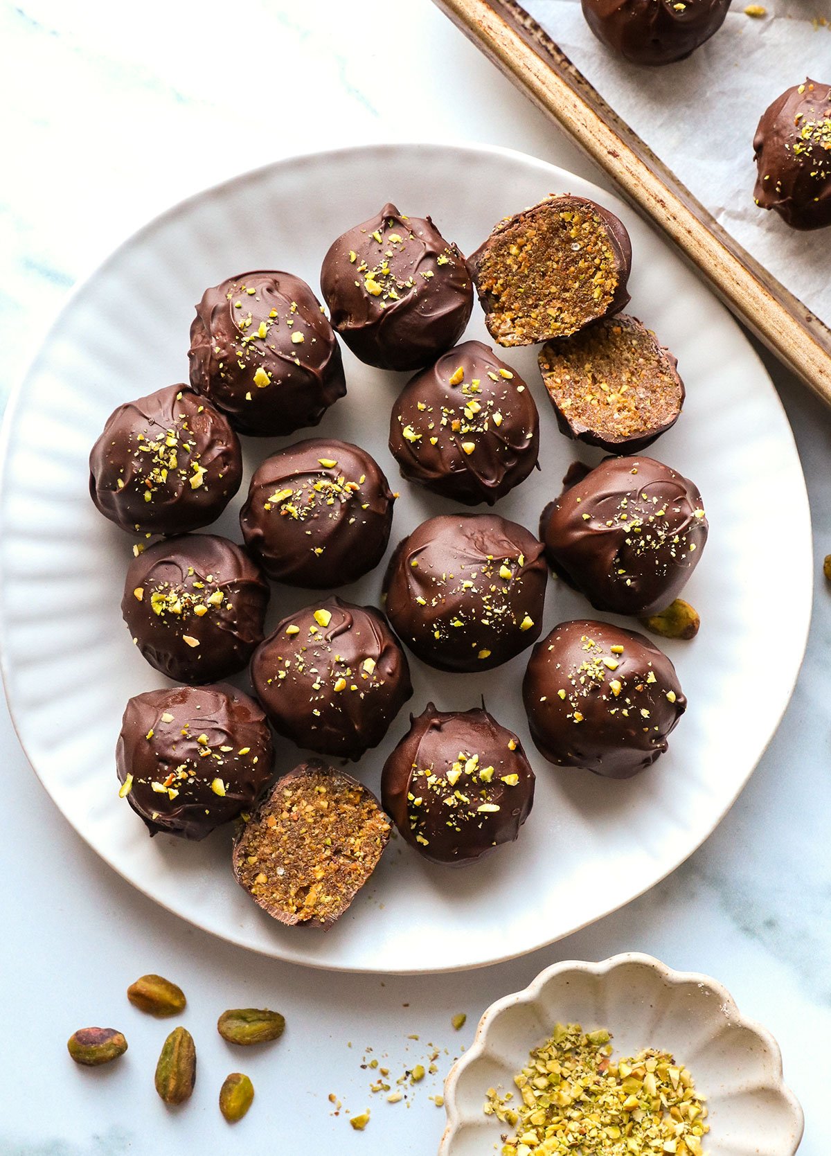 chocolate pistachio balls on a white plate.