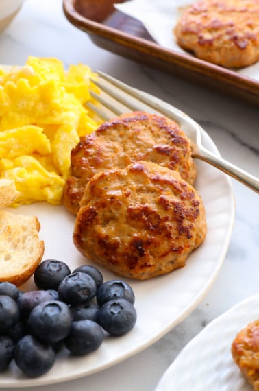 healthy turkey sausage on a plate with berries and eggs.