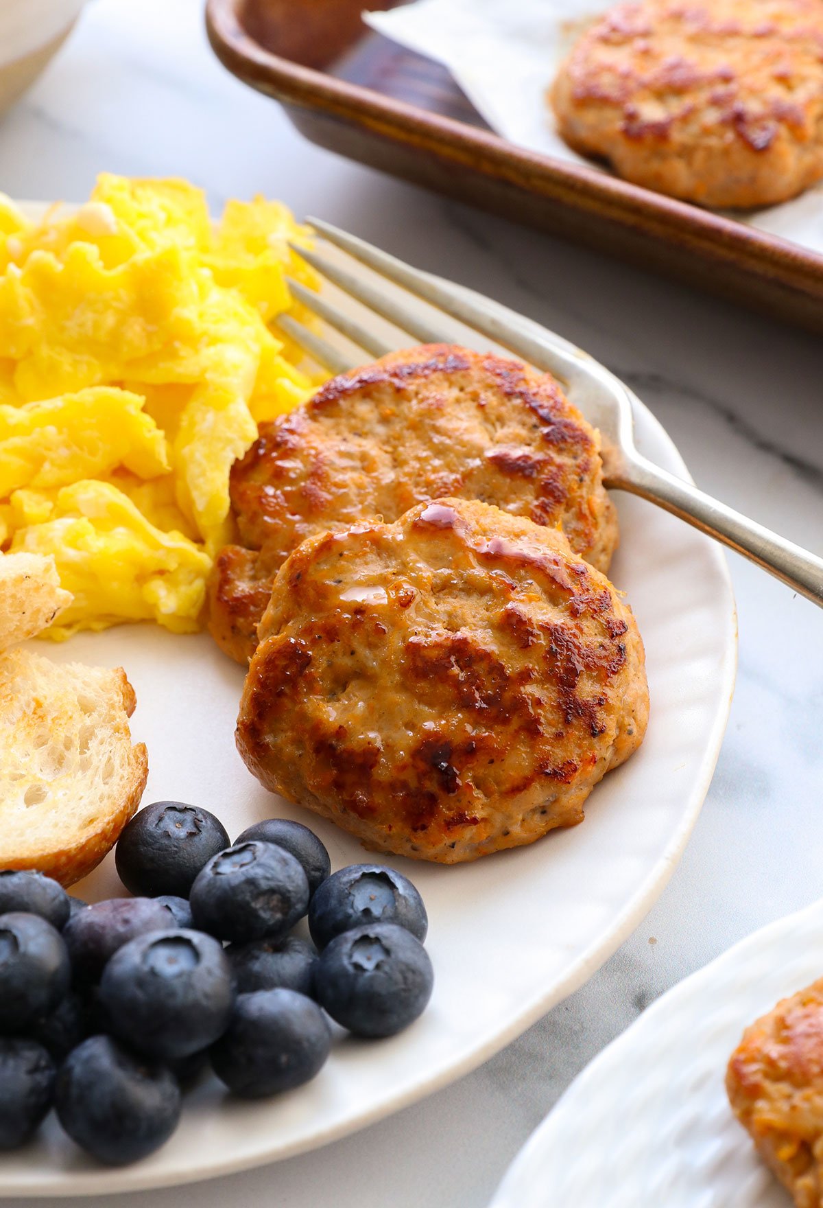healthy turkey sausage on a plate with berries and eggs.