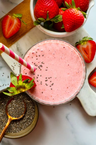 fruit smoothie with chia seeds on top in a glass.