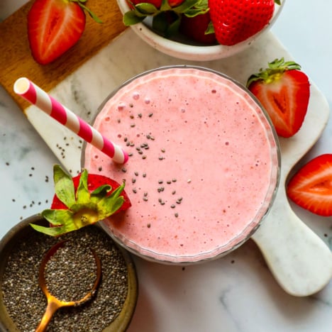 fruit smoothie with chia seeds on top in a glass.