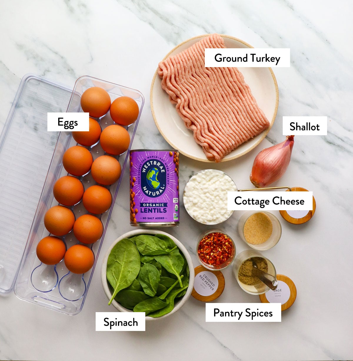eggs, cottage cheese, turkey, lentils, and spices labeled on a white surface. 