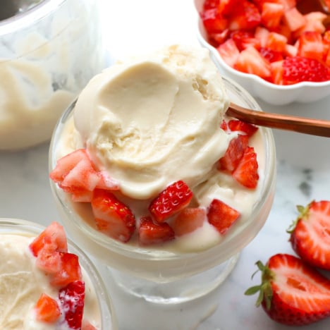 greek yogurt ice cream served in a glass dish with strawberries.