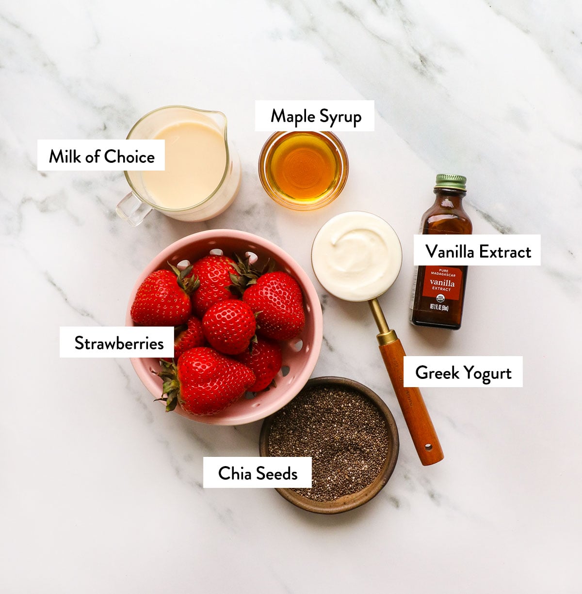 strawberries, greek yogurt, milk, and chia seeds labeled in bowls.