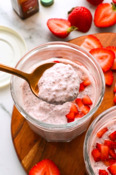 strawberry chia pudding lifted on a spoon to show the texture.