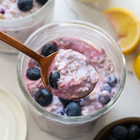 blueberry overnight oats lifted on a spoon.