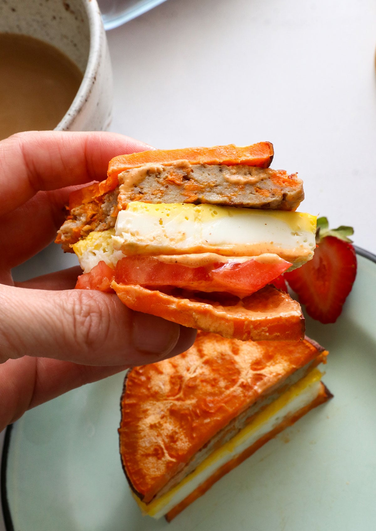 breakfast sandwich made from sweet potato slices, egg, and tomato.