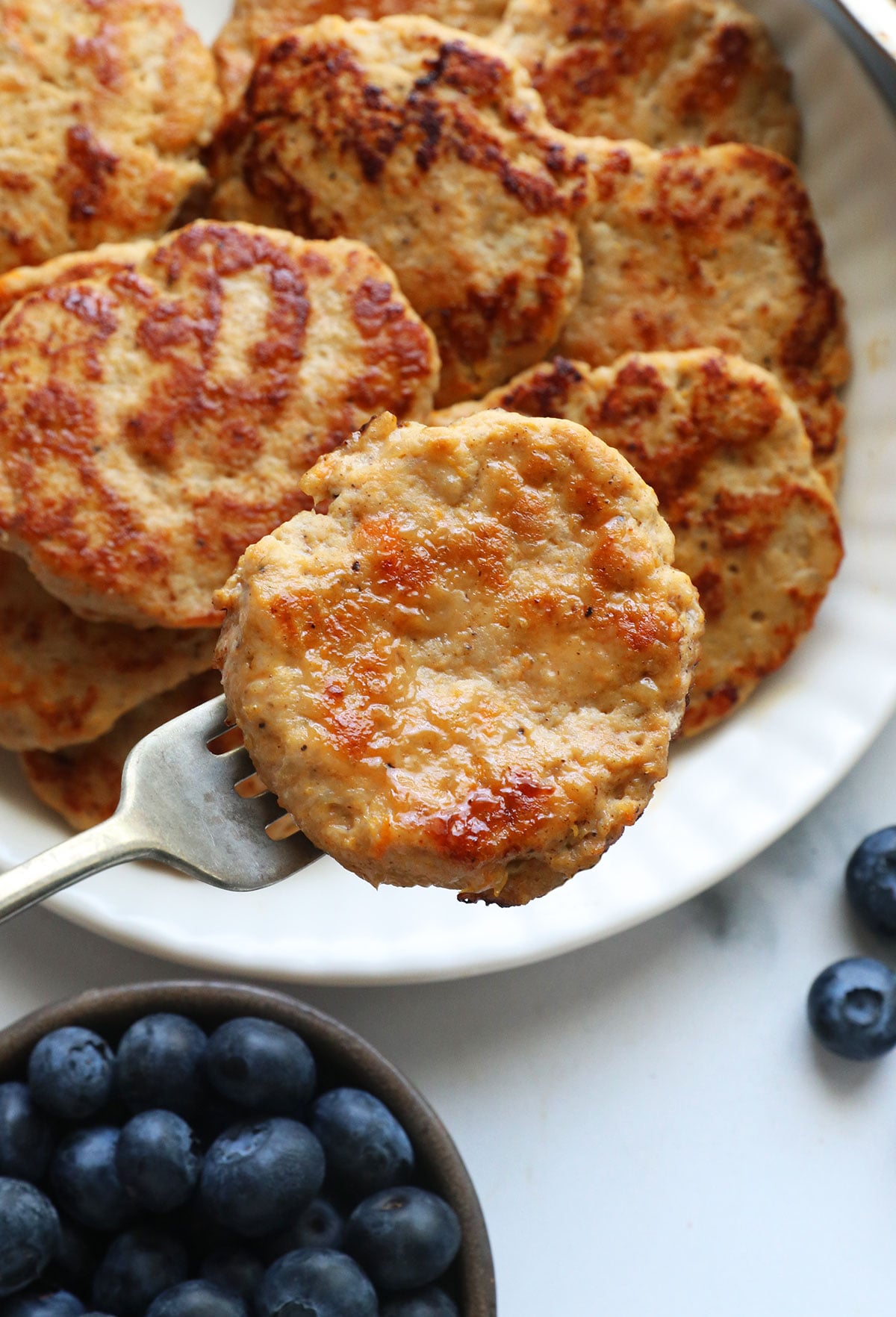 chicken breakfast sausage patty lifted on a fork to show texture.