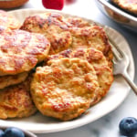 chicken breakfast sausage patties on a plate with berries nearby.