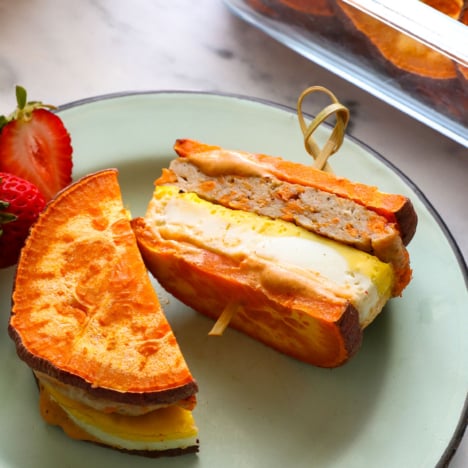 healthy breakfast sandwich sliced in half on a blue plate.