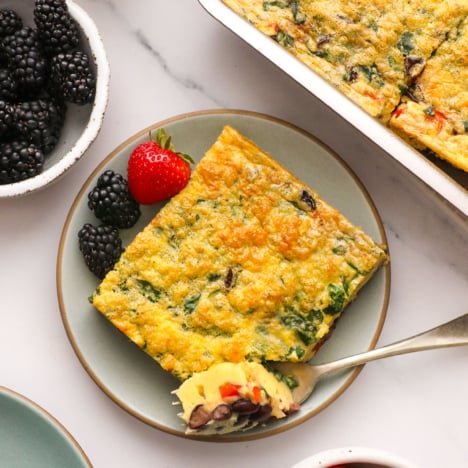 breakfast casserole slice served on a plate with berries.