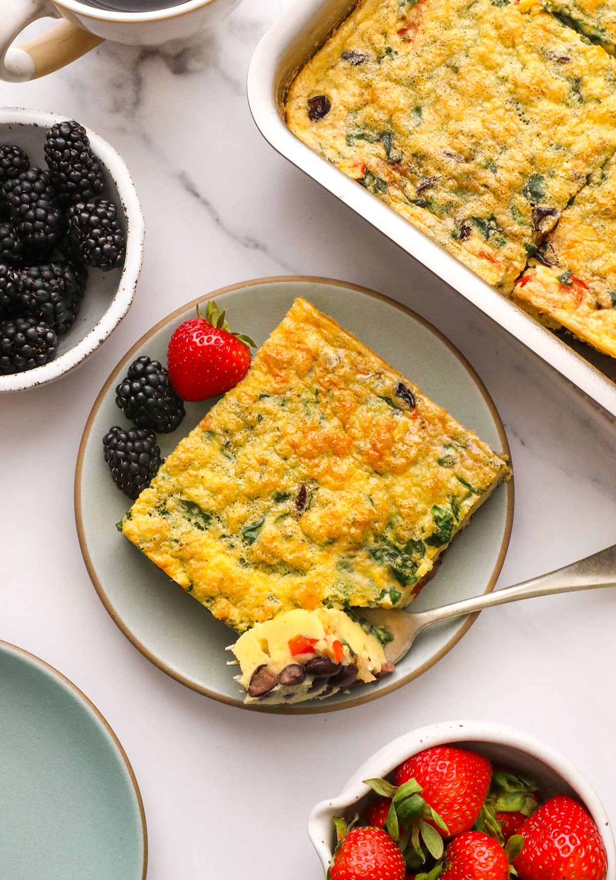 breakfast casserole slice served on a plate with berries.