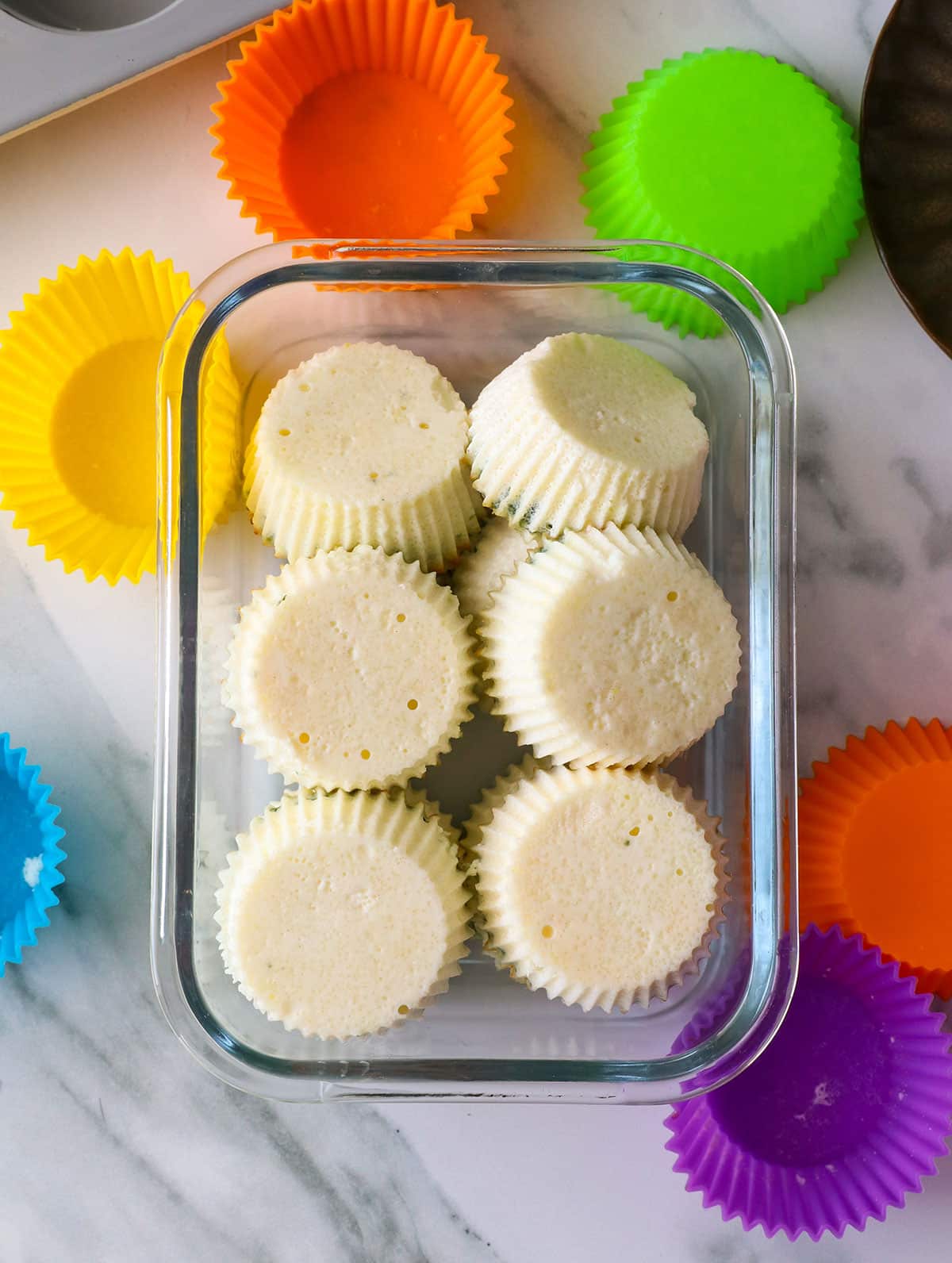 egg white bites added to a glass storage container. 
