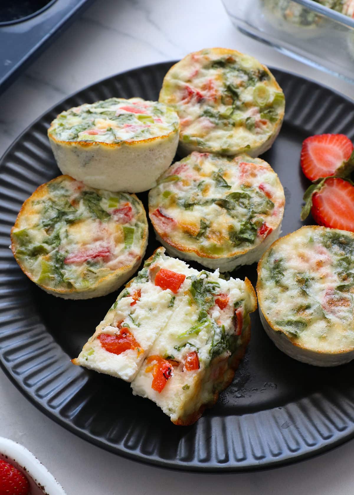 egg white bites served on a dark plate with one split open.