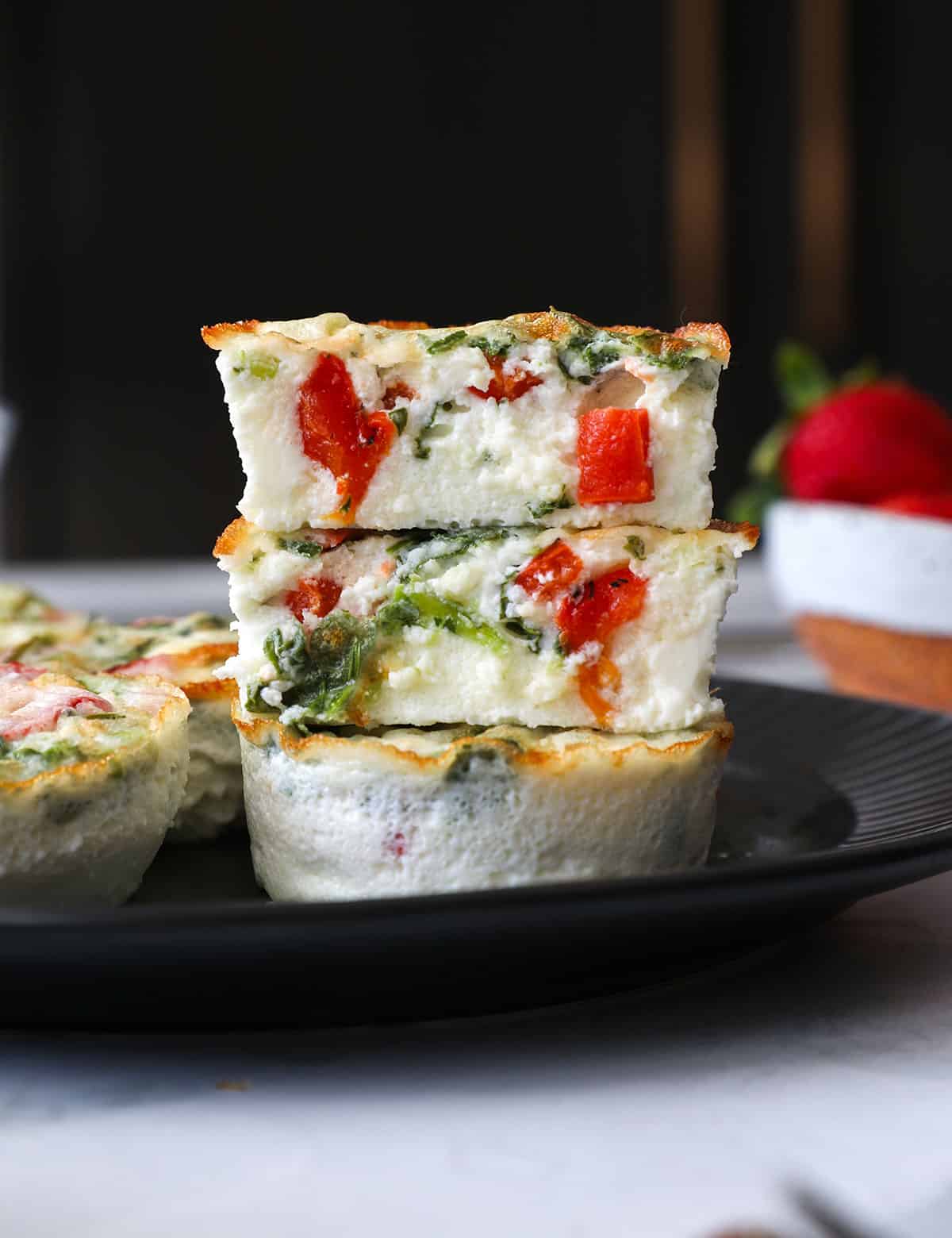 egg white bites stacked on dark plate to show texture. 
