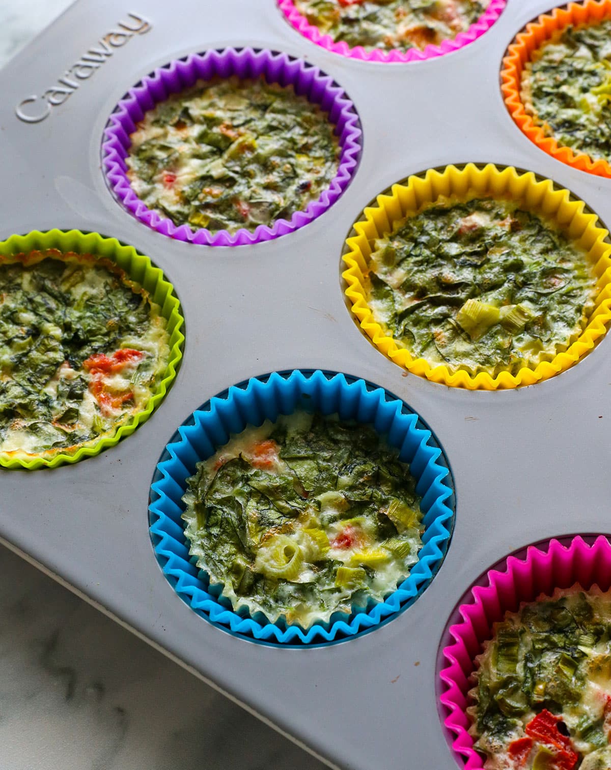 cooked egg white bites cooling in the muffin pan.