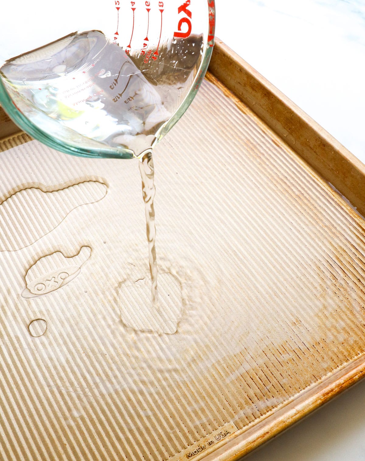 water poured into a rimmed baking sheet for a water bath.