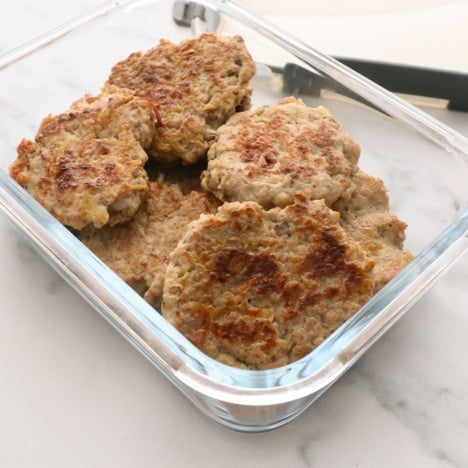 chicken apple sausage in a glass storage container near the lid.