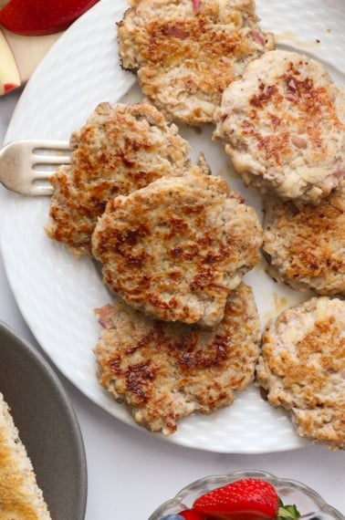 plate full of chicken apple sausage patties with a fork for serving them.