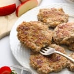 chicken apple sausage patty sitting on a fork on a serving plate.